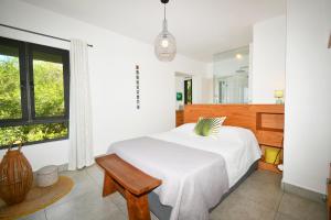 a white bedroom with a bed and a bench at Le Bergamote in Riambel +36 photos