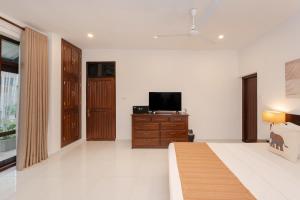a bedroom with a bed and a tv on a dresser at Nature Trails Boutique Hotel in Unawatuna