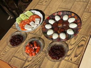 three plates of food on a wooden table at Double Triple Rooms With Lake View balcony in Pogradec +25 photos
