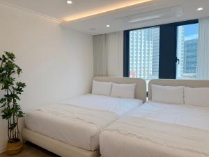 two beds in a room with large windows at Stay in Waves in Ch'ŏngsap'o +83 photos
