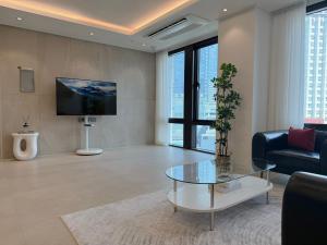 a living room with a glass table and a tv at Stay in Waves in Ch'ŏngsap'o