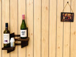 two bottles of wine on a wooden wall at Leo's Cozy Cabin in Ella