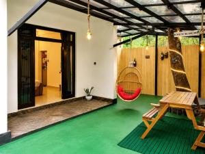 a house with a green floor and a hammock at Leo's Cozy Cabin in Ella