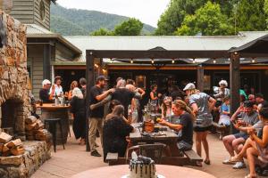 a group of people sitting at tables in a patio at Harrietville Hotel Motel in Harrietville