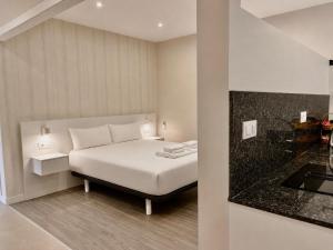 a bedroom with a white bed and a glass door at O Lar de LUCI in Nigrán