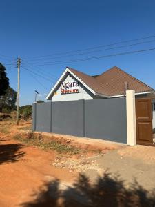 a building with a sign on the side of it at Ngara Sleasure in Songea