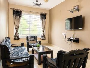 a living room with chairs and a flat screen tv at Casafern Homestay Goa in Varca