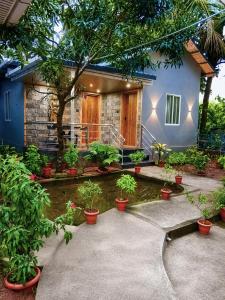 a house with potted plants in front of it at Shilpa Serenity in Kāsarkod