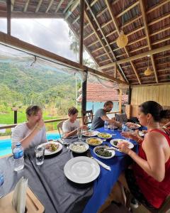 a group of people sitting at a table eating food at Visari Fall Villa Ella in Ella