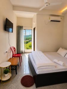 a bedroom with a bed and a table and a television at White Lily in Guwahati
