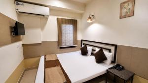 a room with a bed and a television in it at Smyle Inn - Comfort & Value near New Delhi Railway Station - since 1998 in New Delhi