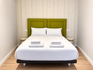a large bed with a green headboard in a room at O Lar de LUCI in Nigrán