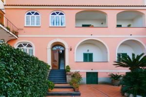 a pink house with stairs leading up to the door at Casa al Belvedere in Vico Equense +26 photos