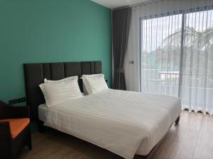 a bedroom with a large bed with a large window at The Hidden Place Bangtao in Bang Tao Beach