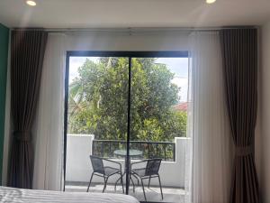 a bedroom with a balcony with a table and chairs at The Hidden Place Bangtao in Bang Tao Beach