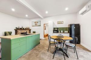 a kitchen with green cabinets and a table and chairs at Jam Cottage Tolmie in Tolmie +12 photos