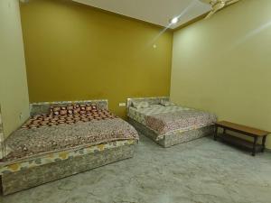 a room with two beds and a table in it at Hotel Shyam Vandan in Rīngas