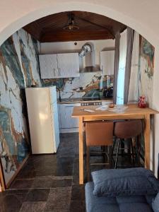 a small kitchen with a table and a refrigerator at Apartments and Rooms "Almira" in Pula