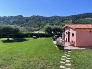 a small pink house with a green yard at CASALE PAGI’ in Grottammare