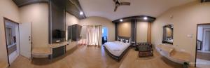 a large room with a bathroom with a tub and a television at Iyal Hotels and Resorts in Salem