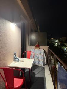 a table and chairs on a balcony at night at CHAMBRE dans appartement moderne guest house in Menton