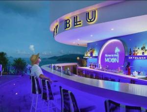 a woman sitting at a bar at a restaurant at Ocean Win Panorama Nha Trang in Nha Trang +76 photos