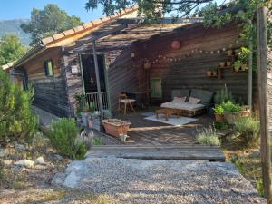 a wooden cabin with a porch and a bench at Chambres d'hôtes " Casa della Felicità " in La Roche-sur-le-Buis +7 photos
