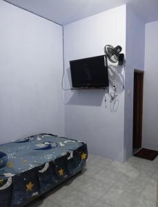 a bedroom with a bed and a tv on a wall at DMP Homestay in Ketapang