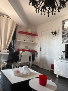 a living room with a table and chairs and a chandelier at CHAMBRE dans appartement moderne guest house in Menton