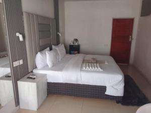 a large white bed in a hotel room at Munjiz Lodge in Livingstone