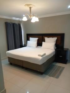 a bedroom with a bed with white sheets and pillows at Munjiz Lodge in Livingstone