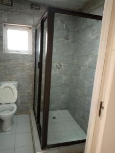 a bathroom with a shower with a toilet at Munjiz Lodge in Livingstone