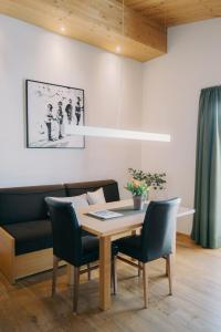 a dining room with a table and chairs and a couch at Das Tannberg in Lech am Arlberg