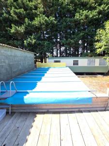 a row of blue yoga mats on a wooden deck at Le bungalow des champs in Saint-Georges-de-Reintembault