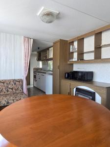 a kitchen with a wooden table in a room at Le bungalow des champs in Saint-Georges-de-Reintembault