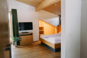 a bedroom with a bed and a flat screen tv at Das Tannberg in Lech am Arlberg