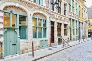 a brick building with green doors on a street at Exceptional double house with Jacuzzi in Lille