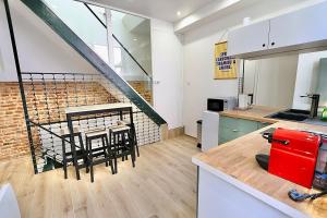 a kitchen with a table and a staircase in a room at Exceptional double house with Jacuzzi in Lille