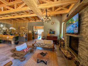 a living room with a stone fireplace with a tv at Ura e Kovacit Resort & Agrotourism in Voskopojë