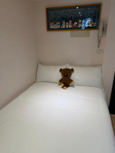 a teddy bear sitting on top of a bed at 山下溫泉民宿 in Yü-shih-ts'un