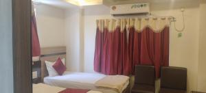 a room with two beds and a red curtain at HoTEL RAJ VIHAR RESIDENCY in Vijayawāda +17 photos