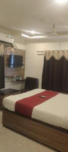 a bedroom with a bed and a chair in a room at HoTEL RAJ VIHAR RESIDENCY in Vijayawāda