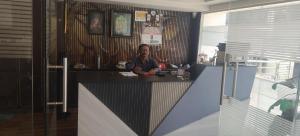 a man sitting at a counter in a kitchen at HoTEL RAJ VIHAR RESIDENCY in Vijayawāda