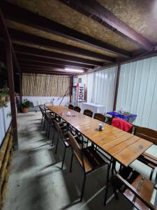 a long wooden table and chairs in a room at Pavillion Guest House in Batumi