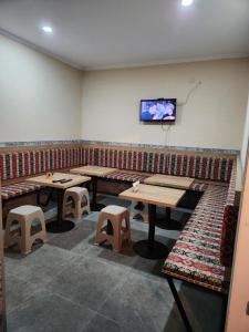 a restaurant with tables and stools and a tv on the wall at Pavillion Guest House in Batumi