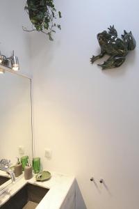 a bathroom with a sink and a frog on the wall at Senhora do Cabo Meco Homy Holidays in Sesimbra