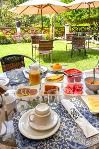 a table with plates of food on top of it at Pousada Vila dos Santos in Porto De Galinhas