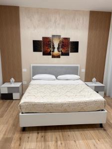 a bedroom with a bed with three paintings on the wall at Marra Home B&B in Barletta