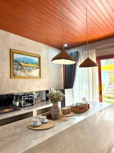 a kitchen with two pendant lights and a table at Alfa Kuta in Kuta Lombok