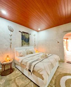 a bedroom with a large bed with a wooden ceiling at Alfa Kuta in Kuta Lombok +32 photos